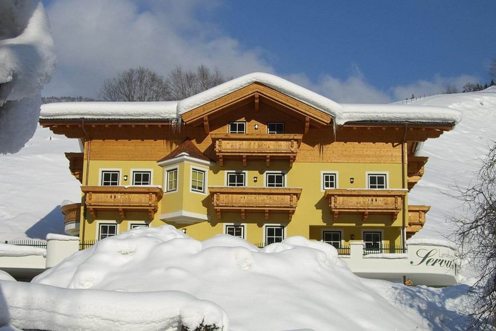 Landhaus Servus in Viehhofen, umgeben von Schnee, ideal für Winterurlaub und Erholung.