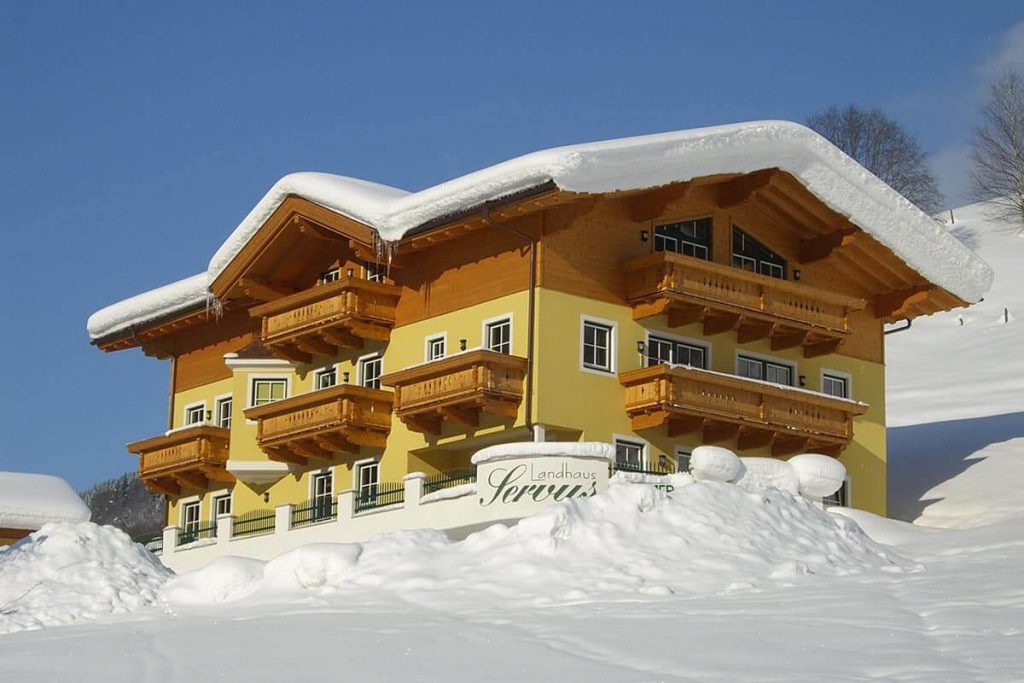 Idyllisches Landhaus Servus in Viehhofen, umgeben von Schnee und Bergen im Winter.